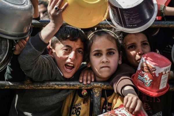 Muhamad y Reham, esperan que se les entregue alimentos. Rafah, 2024.