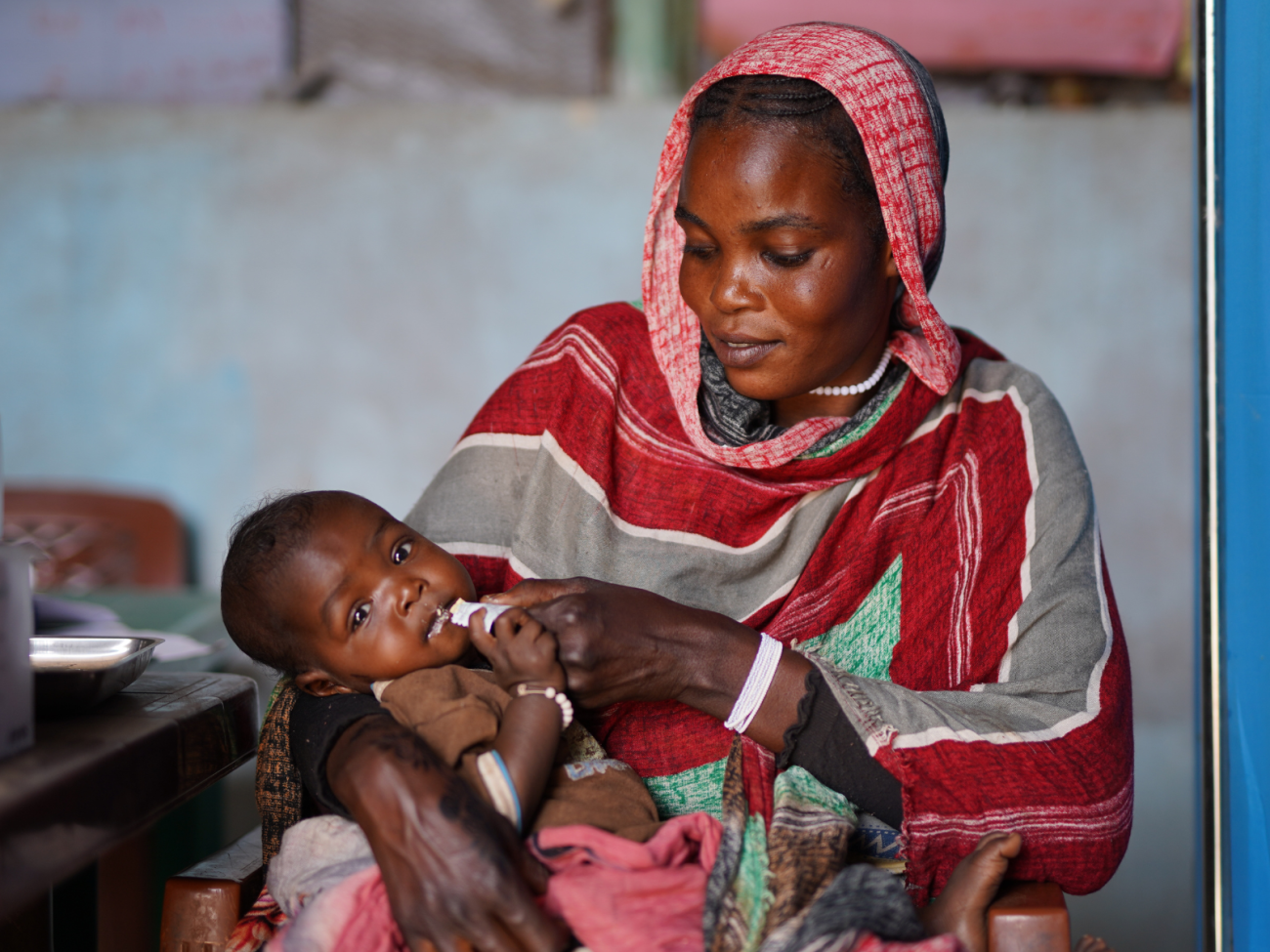 Halimah le entrega alimento terapéutico a su hija de 7 meses.
